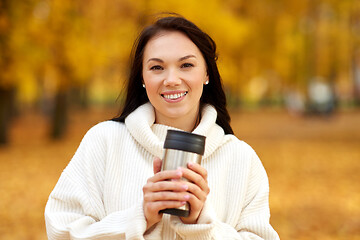 Image showing woman with hot drink in tumbler at autumn park