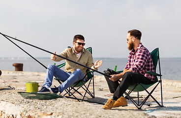 Image showing happy male friends with rods talking about fishing