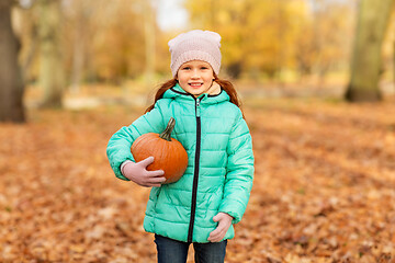 Image showing happy little girl with pumpkin at autumn park