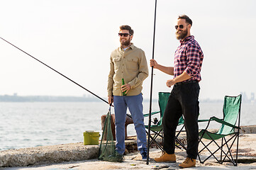 Image showing male friends with fishing rods and beer on pier