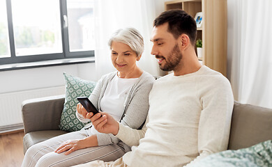 Image showing old mother and adult son with smartphone at home