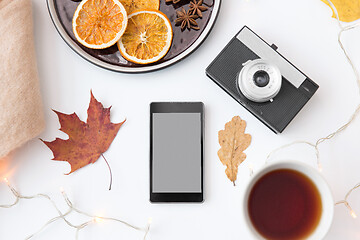 Image showing smartphone, tea, camera, cookies and autumn leaves