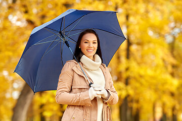 Image showing happy woman with umbrella in autumn park