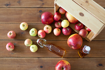 Image showing bottles of apple juice or vinegar on wooden table