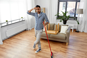 Image showing man with broom cleaning floor at home