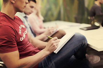 Image showing male student taking notes in classroom