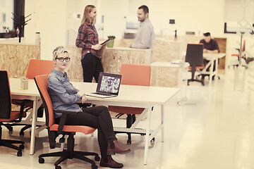 Image showing portrait of young business woman at office with team in backgrou