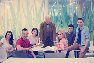 Image showing portrait of  teacher with students group in background