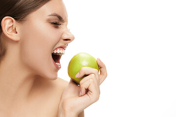 Image showing portrait of attractive caucasian smiling woman isolated on white studio shot eating green apple