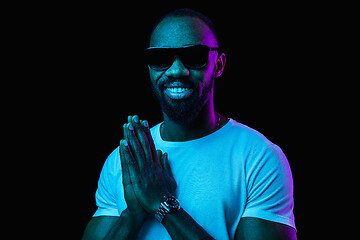 Image showing The neon portrait of a young smiling african man