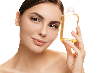 Image showing Beauty concept. The pretty woman with perfect skin holding oil bottle