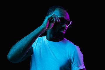 Image showing The neon portrait of a young smiling african man