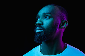 Image showing The neon portrait of a young smiling african man