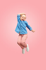 Image showing Young happy caucasian teen girl jumping in the air, isolated on pink studio background.