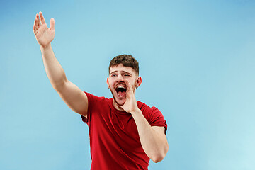 Image showing Isolated on pink young casual man shouting at studio