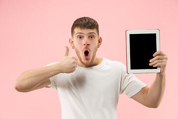 Image showing portrait of smiling man pointing at laptop with blank screen isolated on white