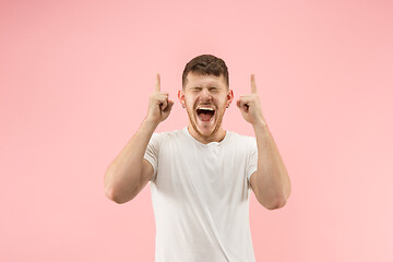 Image showing The young attractive man looking suprised isolated on pink