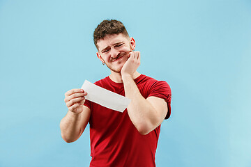 Image showing Young boy with a surprised expression bet slip on blue background