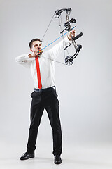 Image showing Businessman aiming at target with bow and arrow, isolated on white background