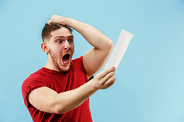 Image showing Young boy with a surprised expression bet slip on blue background