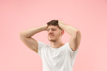 Image showing Man having headache. Isolated over pink background.