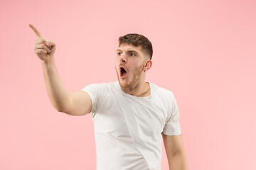 Image showing The young attractive man looking suprised isolated on pink