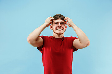 Image showing Young boy with a surprised expression bet slip on blue background