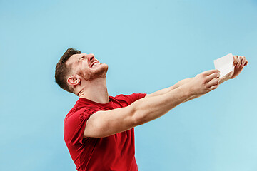 Image showing Young boy with a surprised expression bet slip on blue background