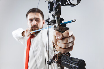 Image showing Businessman aiming at target with bow and arrow, isolated on white background