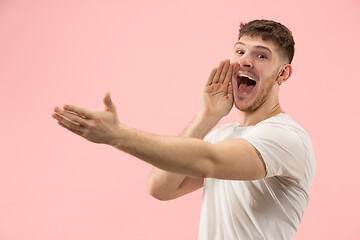 Image showing Isolated on pink young casual man shouting at studio