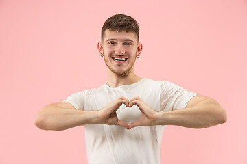 Image showing Attractive guy is making a heart shape symbol with his fingers.