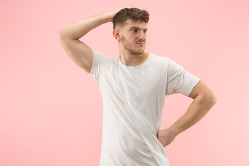 Image showing Beautiful man looking suprised and bewildered isolated on pink