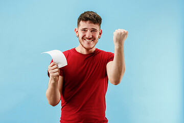 Image showing Young boy with a surprised expression bet slip on blue background