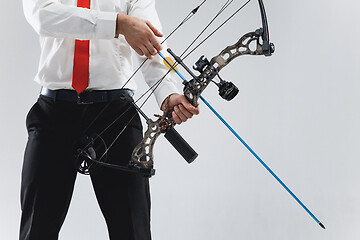 Image showing Businessman aiming at target with bow and arrow, isolated on white background