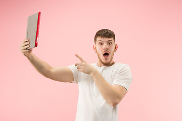 Image showing portrait of smiling man pointing at laptop with blank screen isolated on white