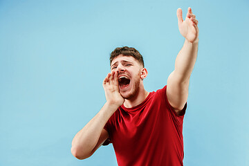 Image showing Isolated on pink young casual man shouting at studio