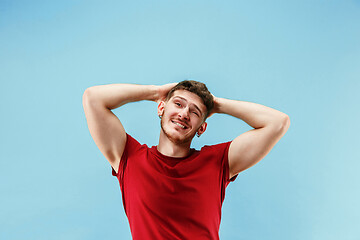 Image showing The happy business man standing and smiling against blue background.