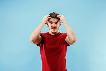 Image showing Young boy with a surprised expression bet slip on blue background