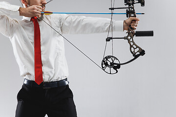 Image showing Businessman aiming at target with bow and arrow, isolated on white background