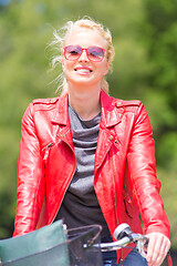 Image showing Young woman riding a bicycle.