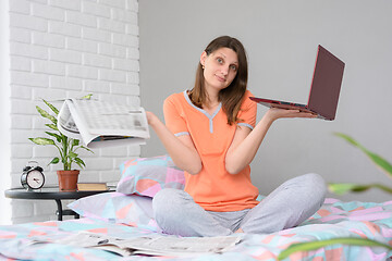 Image showing The girl could not find a job either with the help of a newspaper or with the help of a laptop on the Internet