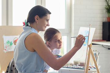 Image showing Drawing teacher shows girl how to draw