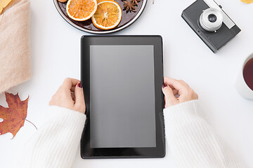 Image showing hands with tablet pc, tea and autumn leaves