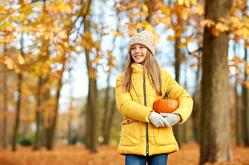 Image showing happy girl with pumpkin at autumn park