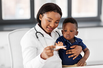 Image showing doctor with measuring baby\'s temperature at clinic