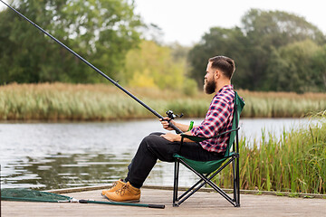 Image showing bearded fisherman with fishing rod