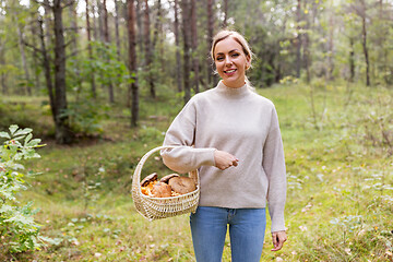 Image showing woman with basket picking mushrooms in forest