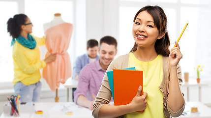 Image showing asian woman with books over fashion design studio