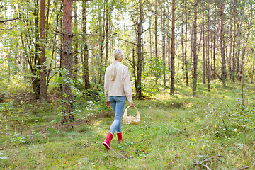 Image showing young woman picking mushrooms in autumn forest