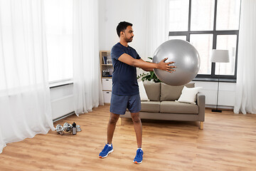 Image showing indian man exercising with fitness ball at home